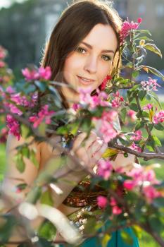 Portrait of pretty young woman posing in flowering trees