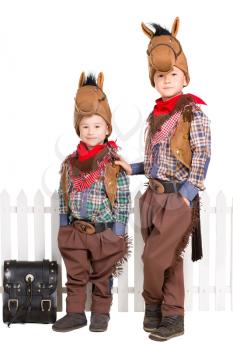 Two boys in horse costumes posing near the fence. Isolated on white