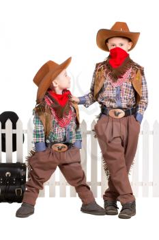 Two boys posing in cowboy costumes. Isolated on white