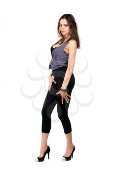 Passionate young brunette wearing tight black leggings and grey vest. Isolated on white