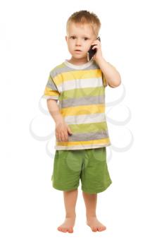Little boy in shorts and t-shirt posing with the mobile phone. Isolated on white
