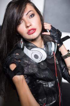Portrait of provocative young brunette posing with headphones