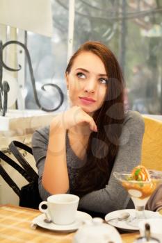 Young thoughtful woman posing in a cozy cafe