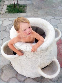 Royalty Free Photo of a Boy Sitting in a Vase