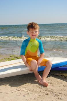 Royalty Free Photo of a Boy Sitting on a Surfboard