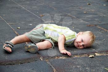 Royalty Free Photo of a Little Boy Laying on the Ground