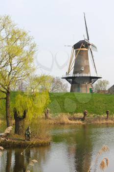 Statue of the fisherman on the background of a windmill in Gorinchem. Netherlands