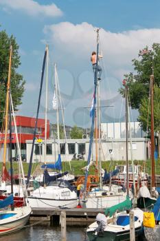 The man at the mast sailing yacht in the port of Huizen. Netherlands
