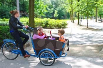 Young girl transporting children in the cart . Amsterdam. Netherlands