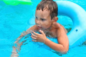 Preschool boy swims in pool on summer vacations