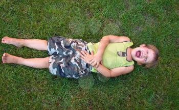 Baby laughing, lying on the grass
