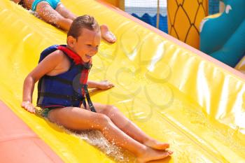 Enthusiastic children on slide in the waterpark