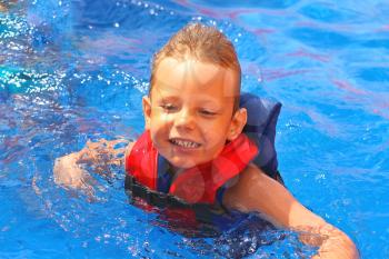 Enthusiastic kid in vest at the pool water park