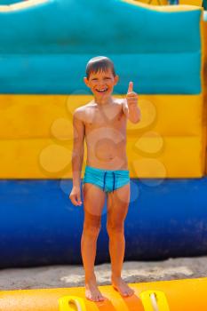 Smiling boy on blue swimming trunks during his summer vacation