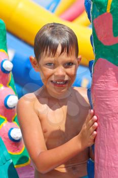 Smiling kid at a water park near the inflatable slides