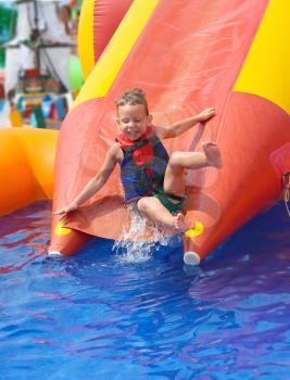 Enthusiastic kid on slide in the waterpark