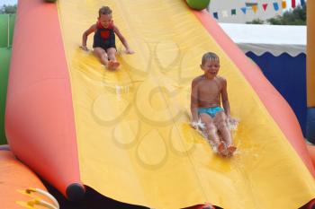 Enthusiastic kids on slide in the water park