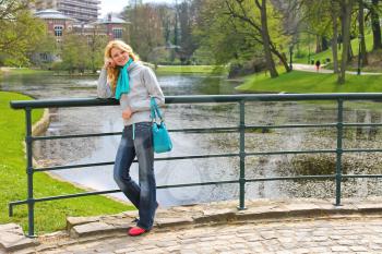 Young beautiful girl on a bridge in a park in Brussels