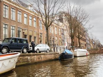 AMSTERDAM,THE NETHERLANDS - FEBRUARY 18, 2012 :   Houses and boats on the canal in Amsterdam . Netherlands