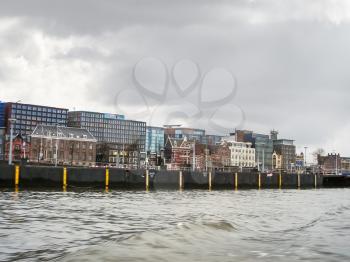 AMSTERDAM,THE NETHERLANDS - FEBRUARY 18, 2012 :  Embankment and modern buildings  in Amsterdam. Netherlands