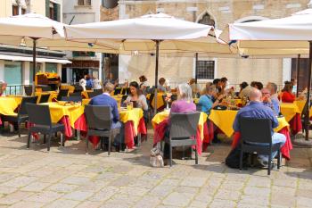 VENICE, ITALY - MAY 06, 2014: Tourists rest at the tables in an outdoor cafe  in Venice, Italy