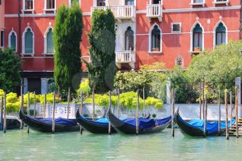 Gondolas at berth of the Grand Canal near the picturesque mansion in Venice, Italy