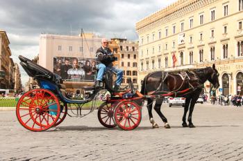 ROME, ITALY - MAY 03, 2014: Coachman sits on a carriage, pulled by a horse, waiting for tourists to Piazza Venezia in Rome, Italy