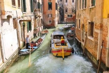 VENICE, ITALY - MAY 06, 2014: People in boats  move along a canal in Venice, Italy 