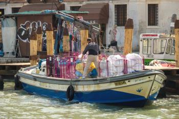 VENICE, ITALY - MAY 06, 2014: Service worker loads into the boat bedclothes , Venice, Italy