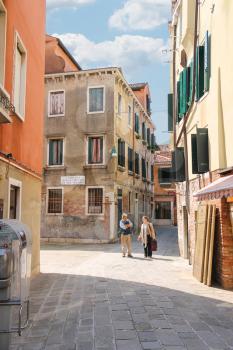 VENICE, ITALY - MAY 06, 2014: Man and woman talking at a crossroads in Venice, Italy