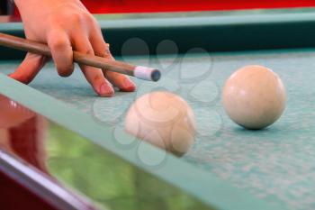 Hand with cue before the a blow to the billiard ball