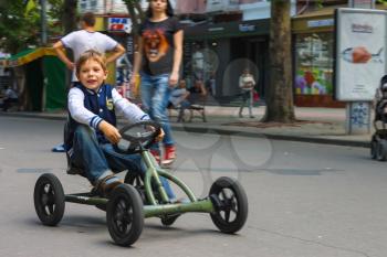 NIKOLAEV, UKRAINE - June 21, 2014: Kid in the play area riding a toy car 
