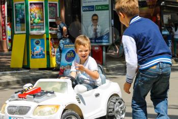 NIKOLAEV, UKRAINE - June 21, 2014: Kids in the play area riding a toy car