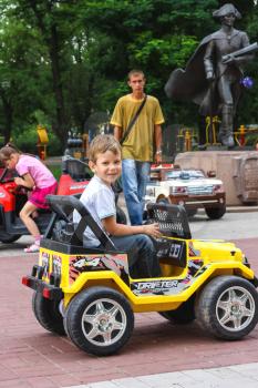 NIKOLAEV, UKRAINE - June 21, 2014: Kids in the play area riding a toy car