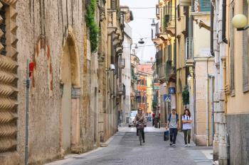 VERONA, ITALY - MAY 7, 2014: People on a narrow street in Verona, Italy