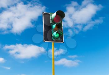 Traffic lights against the sky is lit green