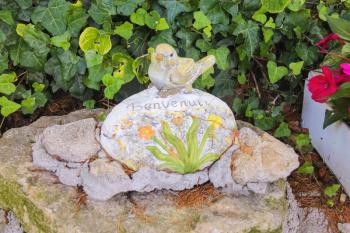 Statuette of a bird with the inscription Benvenuti ( Welcome ) in the Italian garden