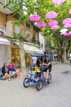 Bellaria Igea Marina, Italy - August 14, 2014: Tourists on a bicycle in the resort town Bellaria Igea Marina, Rimini