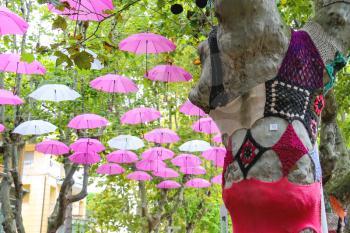 Bellaria Igea Marina, Italy - August 14, 2014: Knitted clothes on trees and umbrellas decorate street in the resort town Bellaria Igea Marina, Rimini, Italy