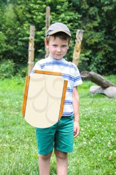 Cheerful boy with a wooden shield and sword