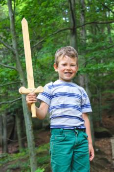Boy with sword on a walk in the park.