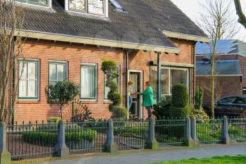 Meerkerk, municipality Zederik, Netherlands - April 13, 2015: Two women chatting on the doorstep in the Dutch town of Meerkerk, Netherlands
