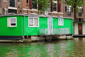 Amsterdam, Netherlands - June 20, 2015: Houseboat on the waterfront canal in Amsterdam