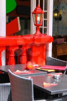 Menu and red candle on black tables of street cafe with red lantern on the background. Zandvoort, the Netherlands