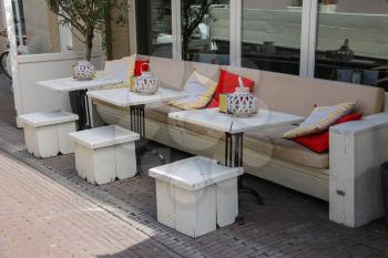 Soft sofas with colorfull pillows in the street cafe terrace. Zandvoort, the Netherlands