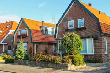 Picturesque residential houses with decorative plants before them in small Dutch town Zwanenburg, the Netherlands