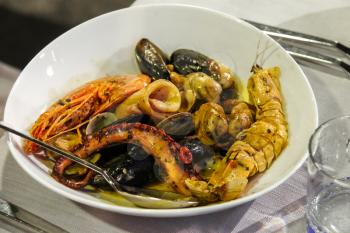 Plate with seafood in traditional Italian restaurant
