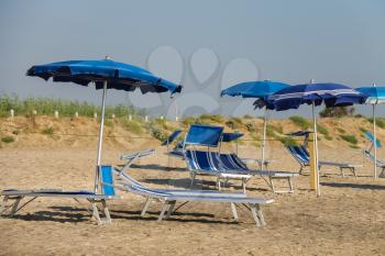 Empty deck chairs under umbrellas on the beach