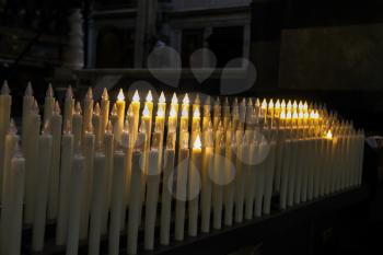 Modern electric candles in the church on dark background