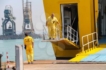 Piombino, Italy - June 30, 2015: Workers prepare a gangway for the exit of passengers in the seaport